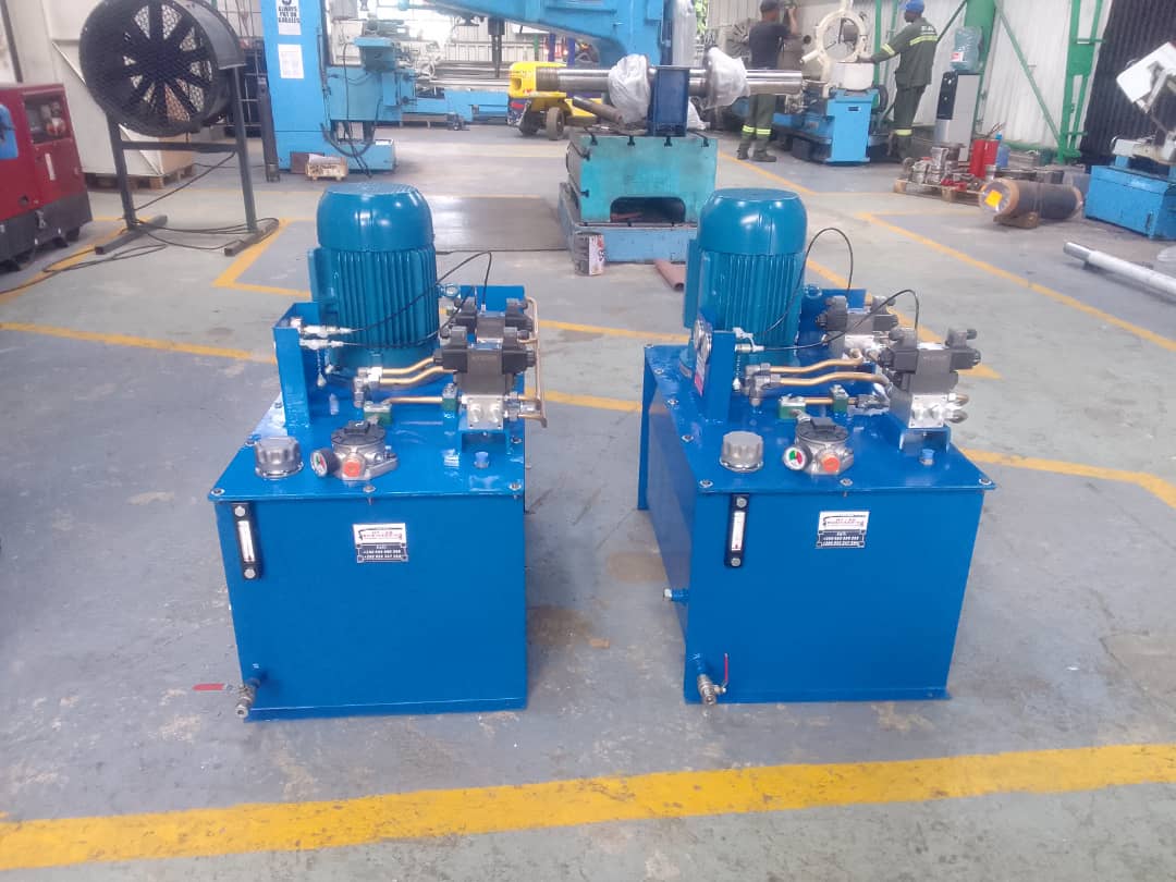 1336799097-IMG-20230116-WA0004 Two blue hydraulic power units in a workshop, used in hydraulic and mechanical engineering services.