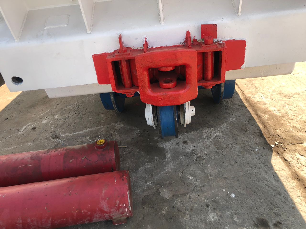 IMG-20240531-WA0013 Industrial mining cart with red and white reinforced coupling and blue wheels, supporting engineering solutions for mining operations.